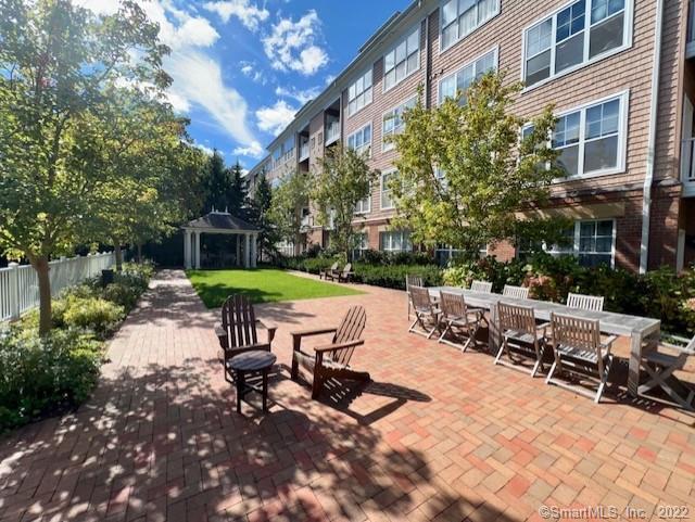 25 Adams Avenue, Unit 301 Stamford, CT 06902 - Photo 5 of 26 a view of a patio with a table and chairs under an umbrella