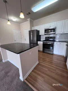 a kitchen with granite countertop a sink a counter space appliances and cabinets