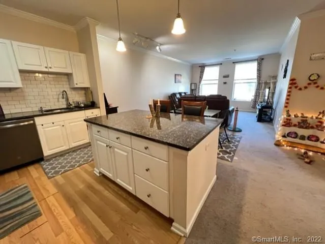 a kitchen with stainless steel appliances granite countertop a sink refrigerator and microwave