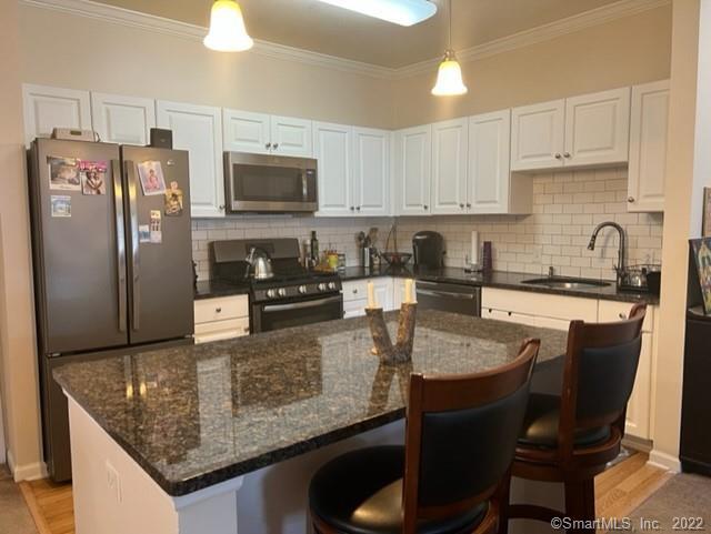 25 Adams Avenue, Unit 301 Stamford, CT 06902 - Photo 10 of 26 a kitchen with stainless steel appliances granite countertop a sink refrigerator and microwave