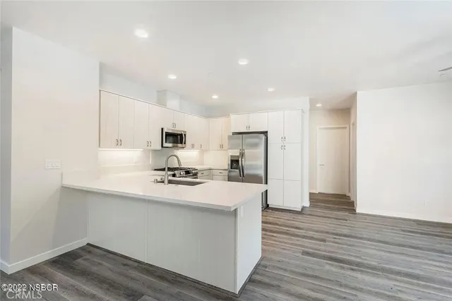 a kitchen with stainless steel appliances a refrigerator and a stove top oven