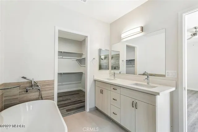 a bathroom with a tub sink and mirror