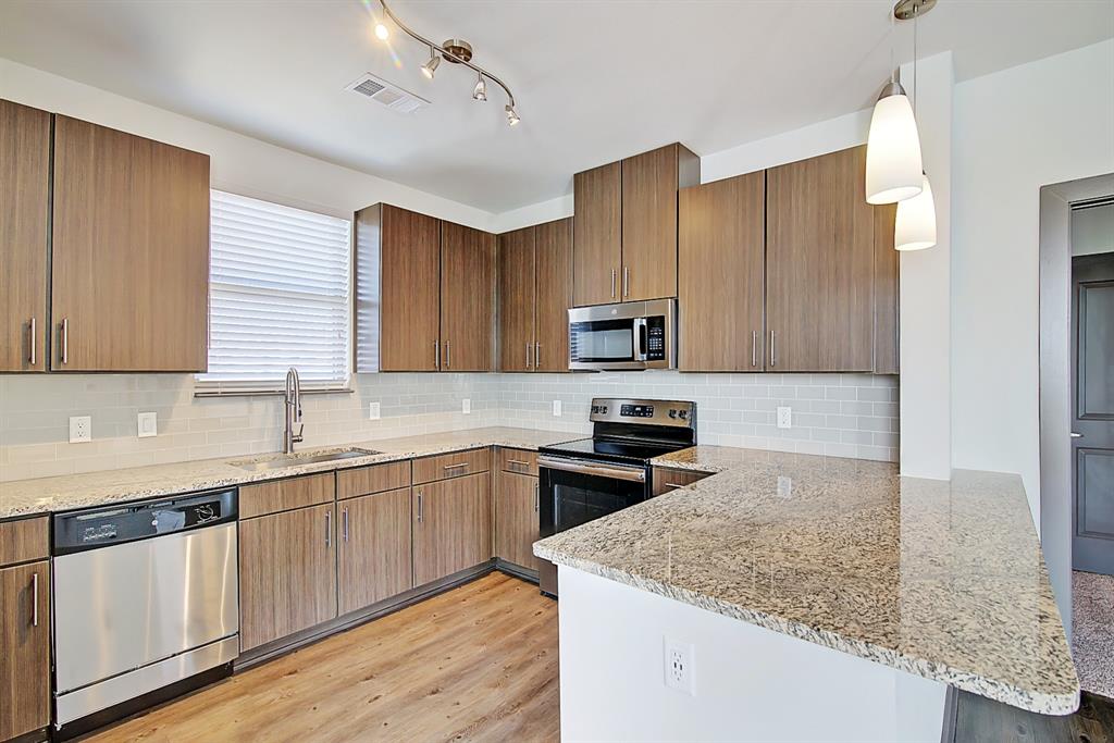 a kitchen with stainless steel appliances granite countertop a sink stove and microwave