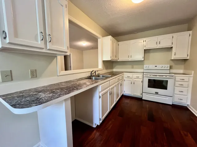 a kitchen with stainless steel appliances granite countertop a sink stove and cabinets