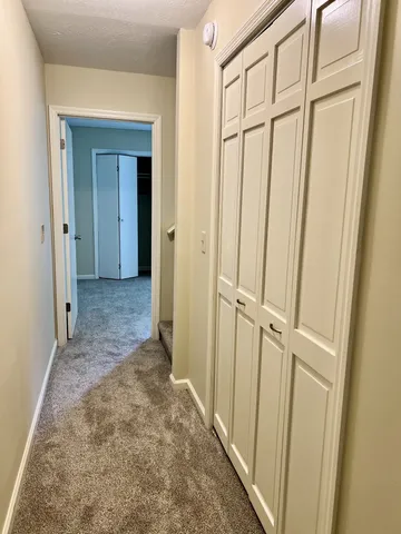 a view of a hallway with wooden floor and closet