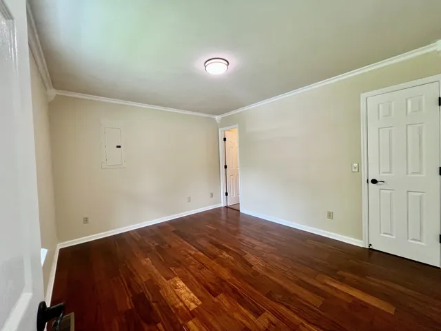 a view of an empty room with wooden floor