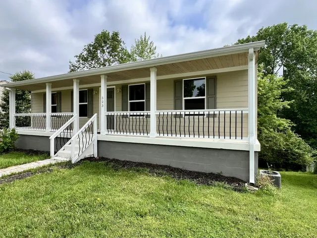 a view of a house with a yard and deck