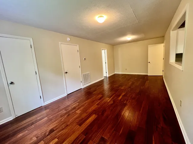 a view of an empty room with wooden floor