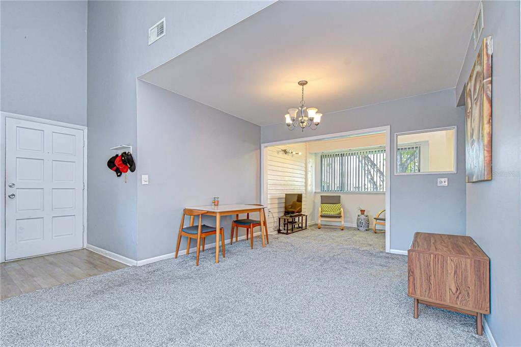 13402 Pinelake Way, Unit 202B Tampa, FL 33618 - Photo 13 of 42 a living room with furniture and a chandelier