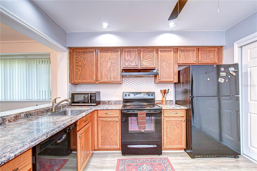 13402 Pinelake Way, Unit 202B Tampa, FL 33618 - Photo 20 of 42 a kitchen with stainless steel appliances granite countertop a refrigerator sink and cabinets