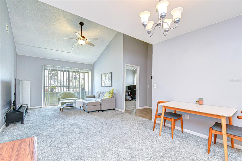 13402 Pinelake Way, Unit 202B Tampa, FL 33618 - Photo 27 of 42 a living room with furniture a chandelier fan and a window