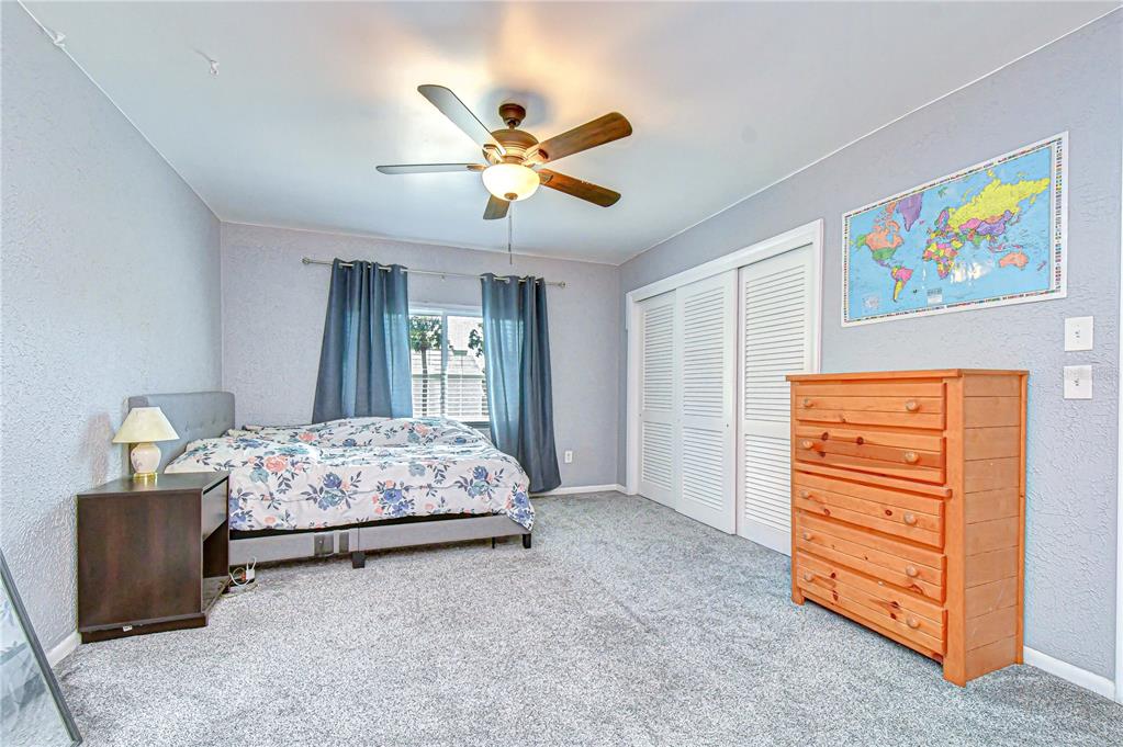 13402 Pinelake Way, Unit 202B Tampa, FL 33618 - Photo 29 of 42 a bedroom with a bed and a dresser in it