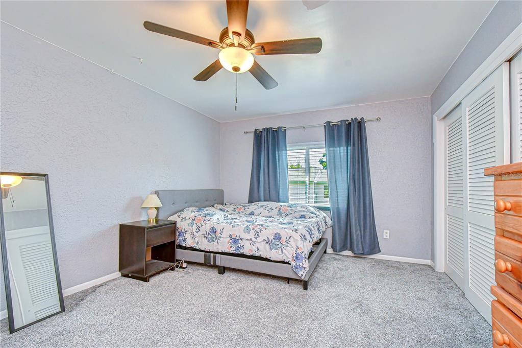 13402 Pinelake Way, Unit 202B Tampa, FL 33618 - Photo 30 of 42 a bedroom with a bed and a chandelier