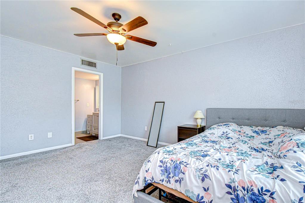 13402 Pinelake Way, Unit 202B Tampa, FL 33618 - Photo 31 of 42 a bedroom with a bed and a chandelier
