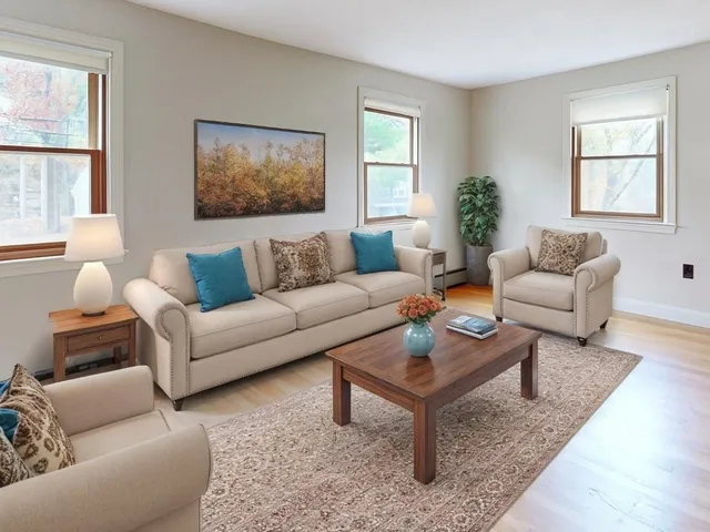 a living room with furniture a rug a window and a lamp