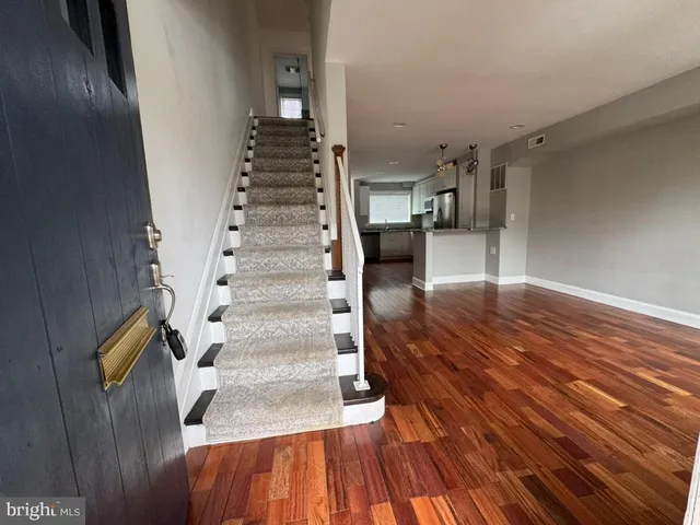 a view of entryway and hall with wooden floor
