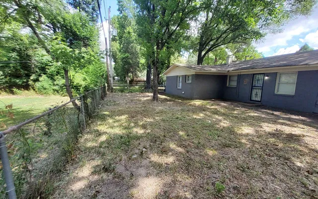 a backyard of a house with table and chairs
