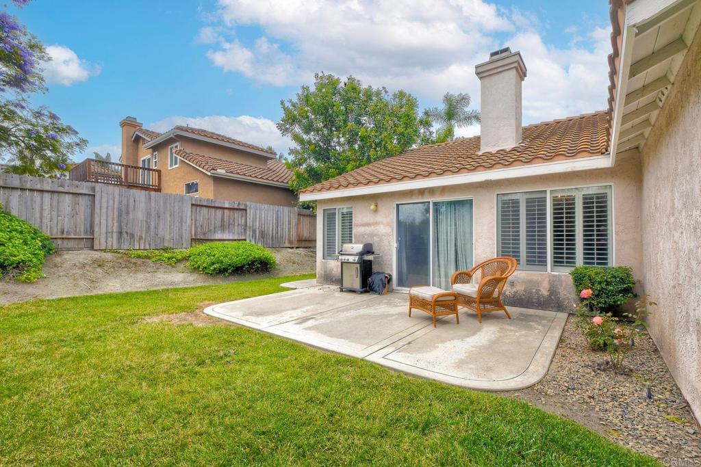 1208 Sunglow Drive Oceanside, CA 92056 - Photo 18 of 20 a backyard of a house with table chairs and wooden fence