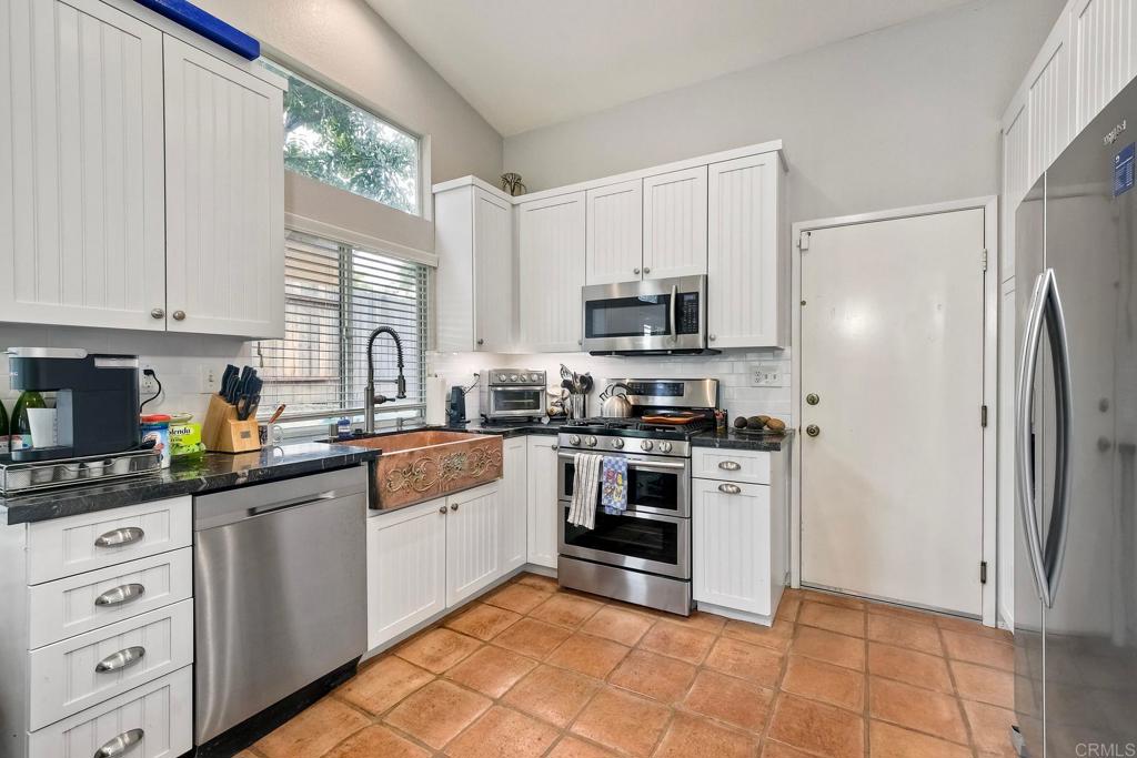 1208 Sunglow Drive Oceanside, CA 92056 - Photo 9 of 20 a kitchen with stainless steel appliances cabinets a sink and a window