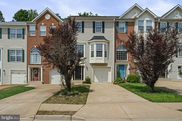 a front view of a house with a yard and trees