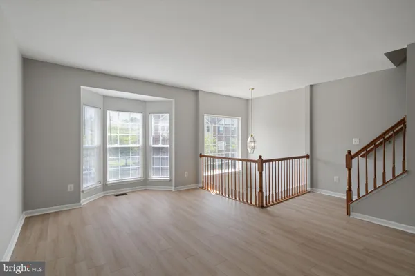a view of a room with wooden floor and windows