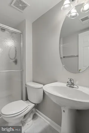 a bathroom with a toilet a sink and mirror