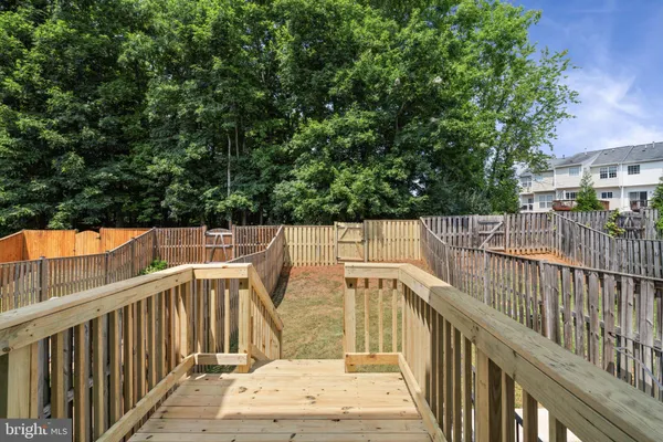 a view of a balcony with wooden floor and fence