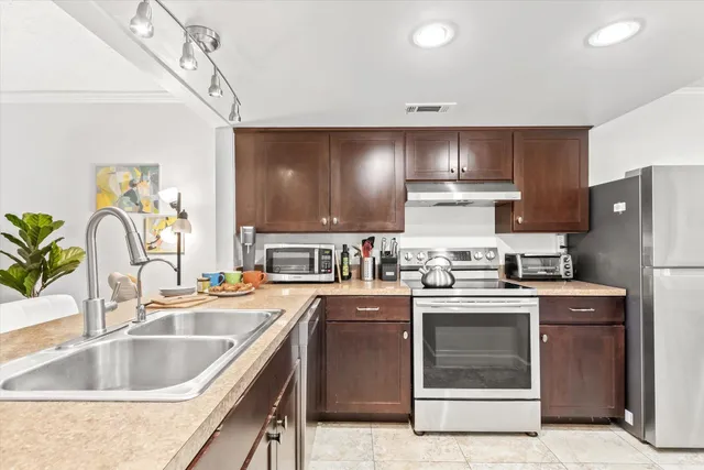 a kitchen with stainless steel appliances granite countertop a sink stove and refrigerator