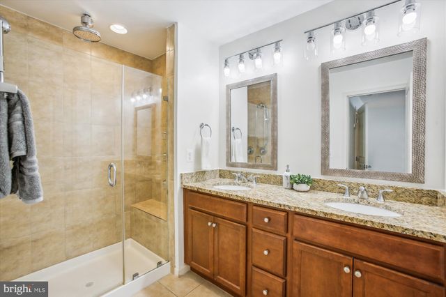 a bathroom with a granite countertop sink mirror and shower