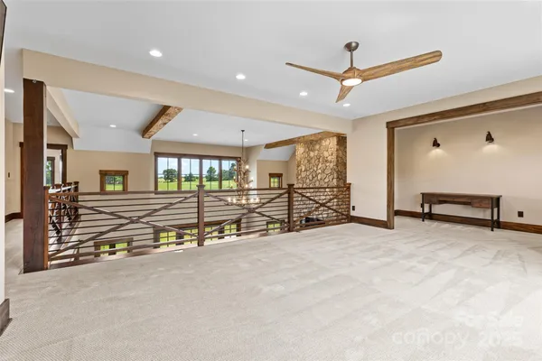an empty room with ceiling fan and wooden floor