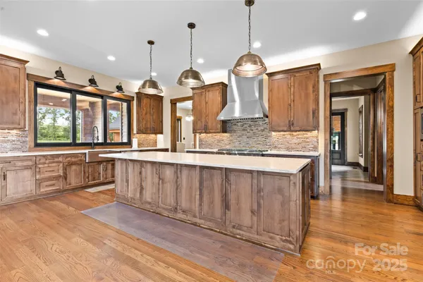 a large kitchen with granite countertop a large kitchen island white cabinets and stainless steel appliances