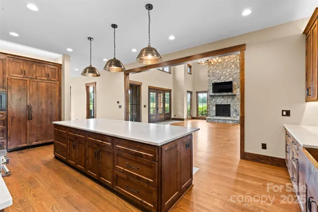 a large kitchen with stainless steel appliances granite countertop a stove and a wooden floors