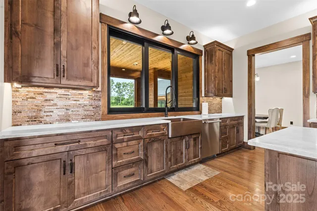 a large kitchen with granite countertop a sink and dishwasher wooden cabinets with a large window