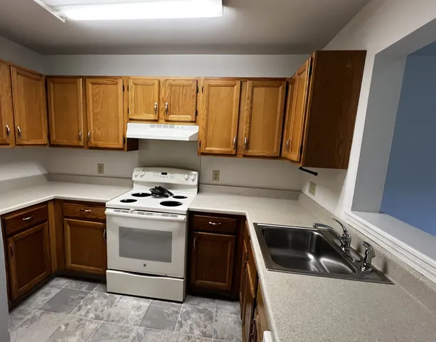 a kitchen with a stove sink and cabinets