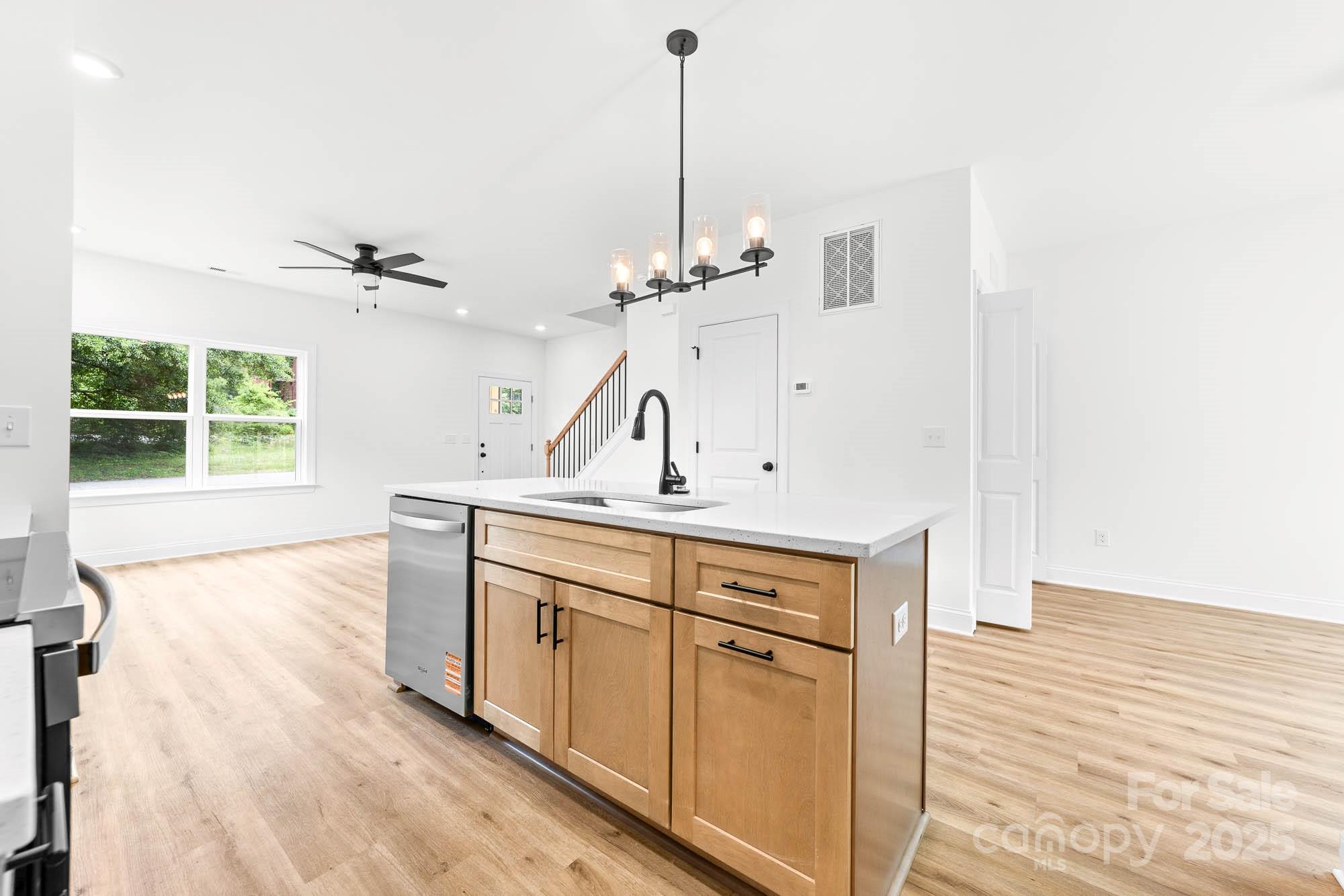 424 Airline Extension Shelby, NC 28150 - Photo 6 of 35 a view of a kitchen with kitchen island a sink wooden floor and a large window