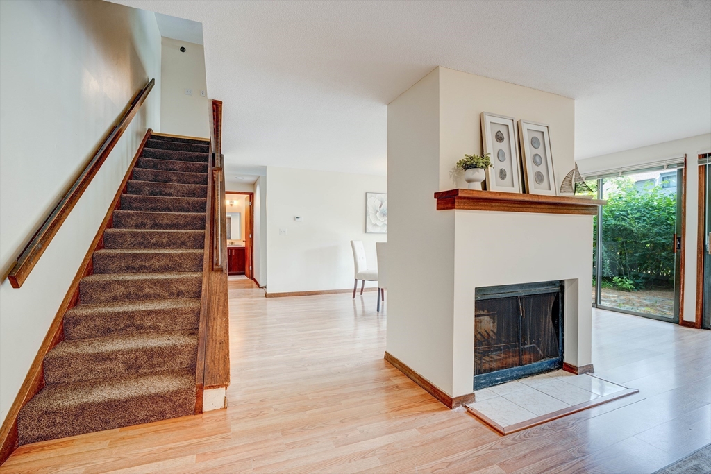 244 Old Beaverbrook, Unit 244 Acton, MA 01718 - Photo 17 of 42 a view of an empty room with wooden floor fireplace and windows
