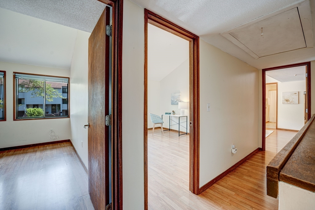 244 Old Beaverbrook, Unit 244 Acton, MA 01718 - Photo 18 of 42 a view of a hallway with wooden floor and windows