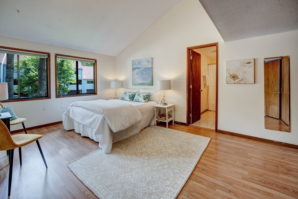 244 Old Beaverbrook, Unit 244 Acton, MA 01718 - Photo 20 of 42 a bedroom with a bed and wooden floor