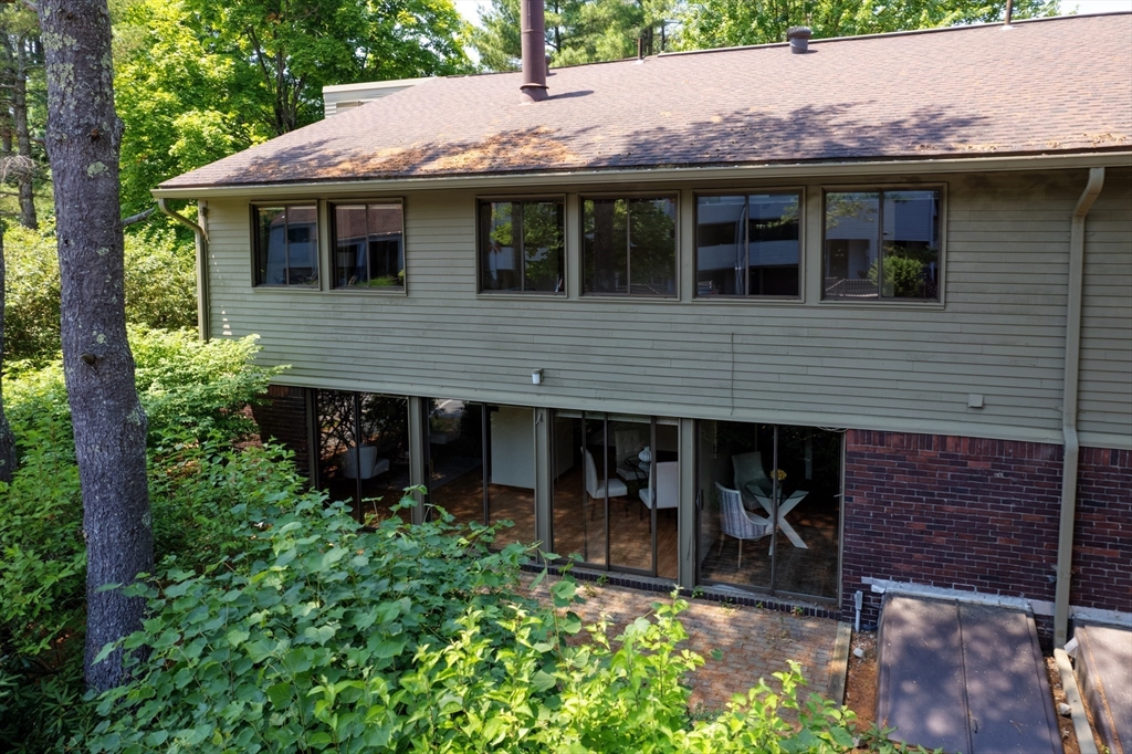 244 Old Beaverbrook, Unit 244 Acton, MA 01718 - Photo 2 of 42 a backyard of a house with table and chairs