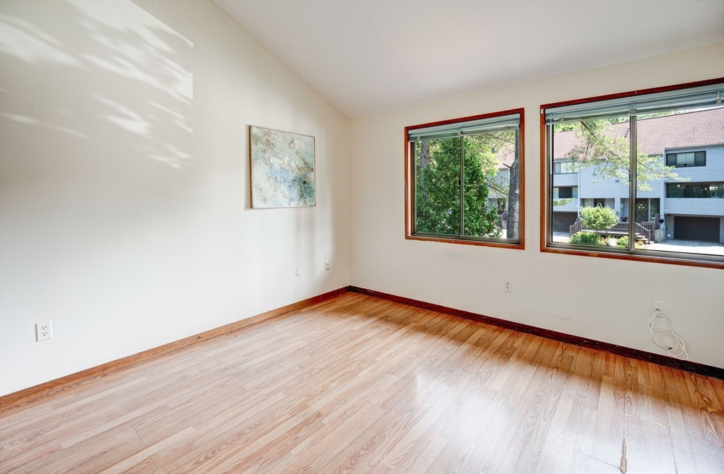 244 Old Beaverbrook, Unit 244 Acton, MA 01718 - Photo 26 of 42 a view of an empty room with wooden floor and a window