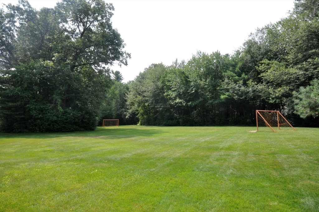 244 Old Beaverbrook, Unit 244 Acton, MA 01718 - Photo 39 of 42 a backyard of a house with lots of green space