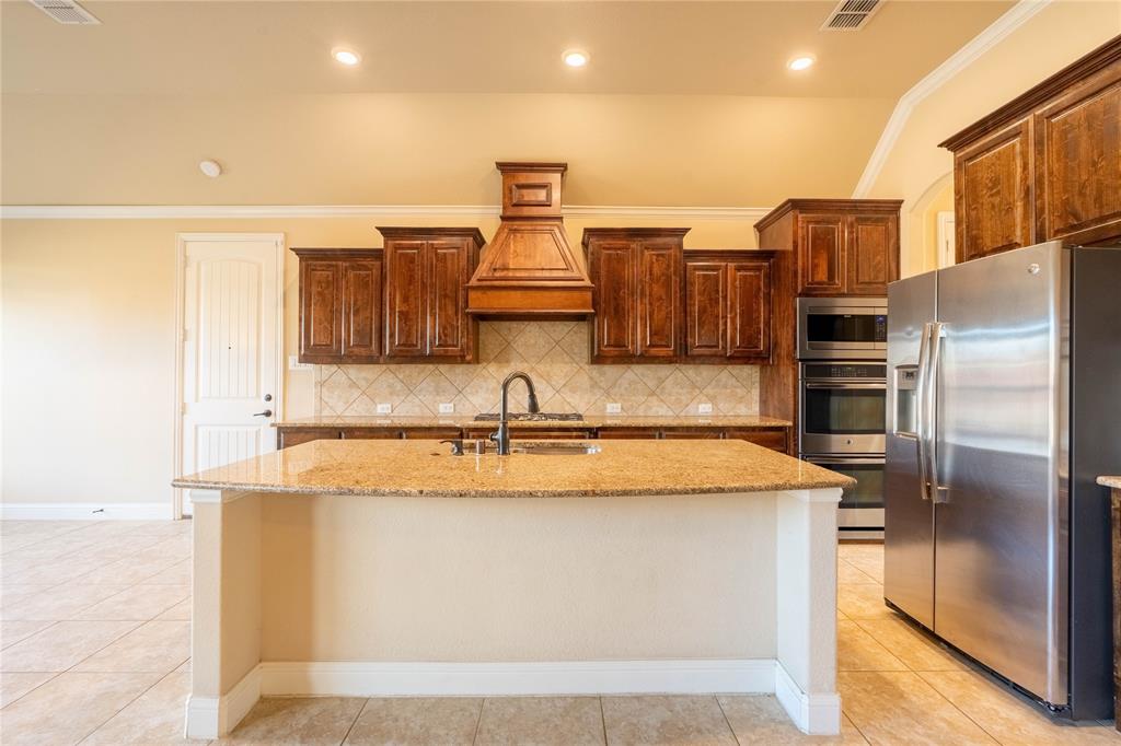 9101 Waters Lane Rowlett, TX 75089 - Photo 16 of 34 a kitchen with stainless steel appliances granite countertop a sink and a refrigerator