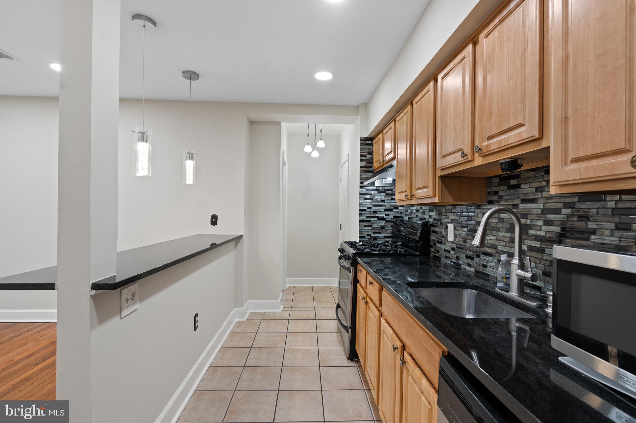 1909 Rosedale Street Northeast, Unit 3 Washington, DC 20002 - Photo 11 of 23 a kitchen with stainless steel appliances granite countertop a sink stove and cabinets