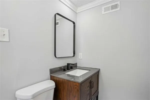 a bathroom with a granite countertop toilet sink and mirror