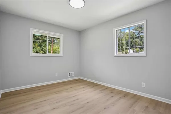 a view of empty room with wooden floor