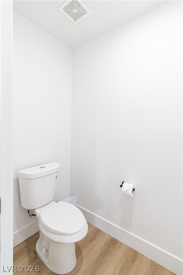 1891 Brian Road Pahrump, NV 89048 - Photo 19 of 50 Bathroom with visible vents, baseboards, toilet, and wood finished floors