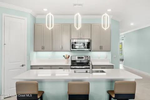a kitchen with kitchen island a sink a stove and a microwave