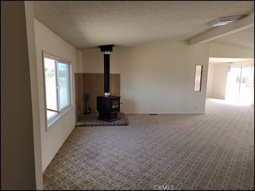 12232 Sheep Creek Road Phelan, CA 92371 - Photo 20 of 45 a view of empty room with a fireplace