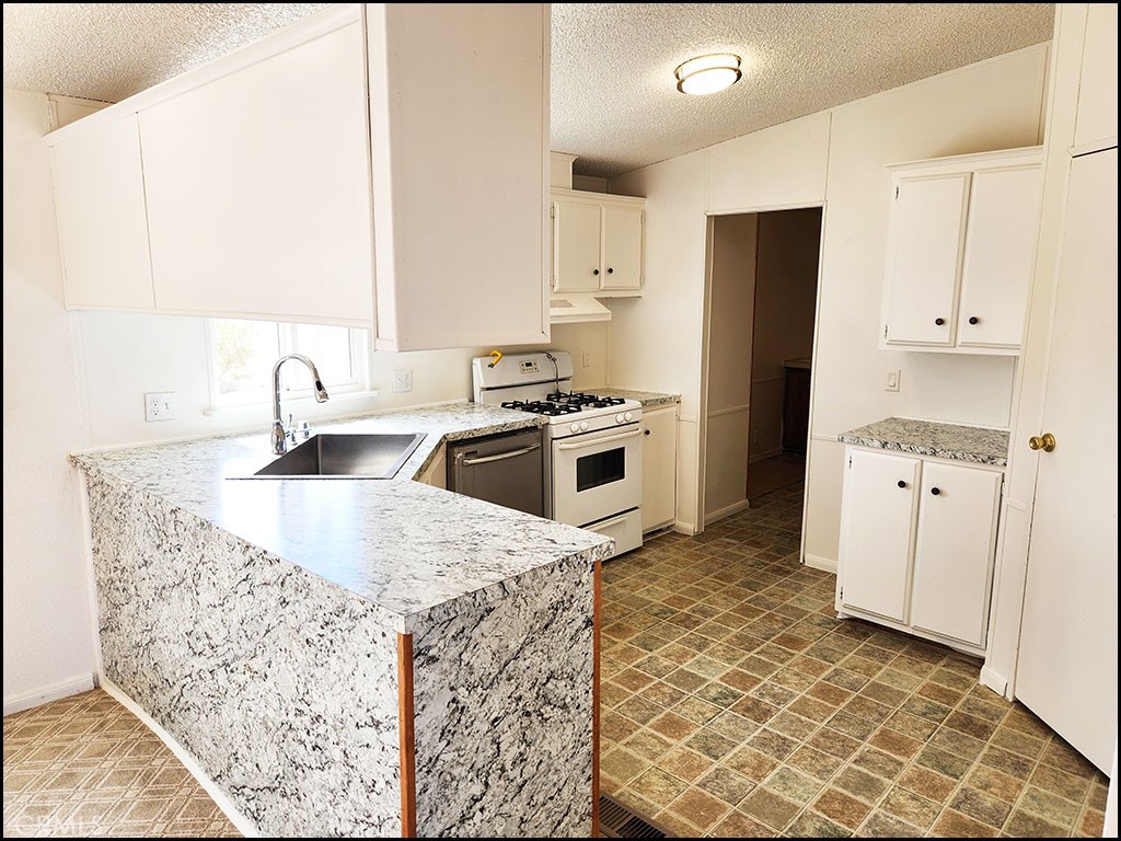 12232 Sheep Creek Road Phelan, CA 92371 - Photo 24 of 45 a kitchen with stainless steel appliances granite countertop a sink stove and refrigerator