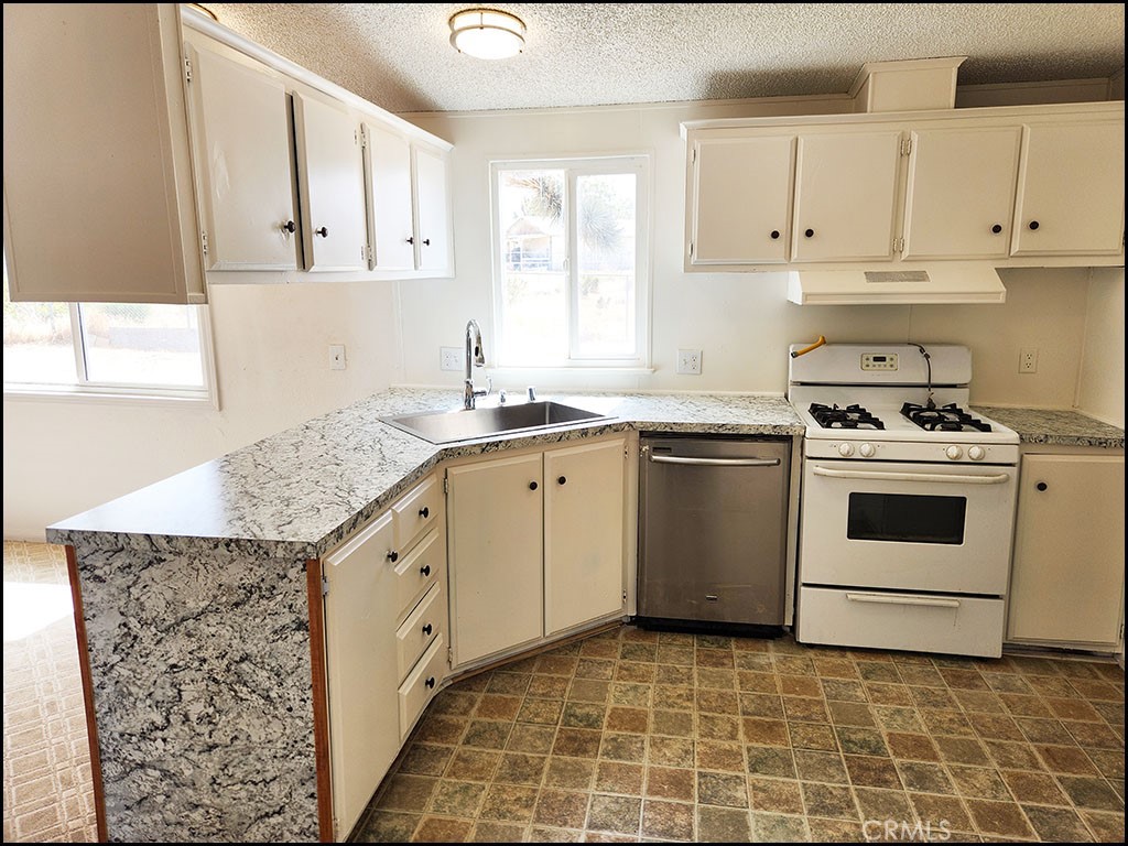 12232 Sheep Creek Road Phelan, CA 92371 - Photo 25 of 45 a kitchen with granite countertop white cabinets and white appliances